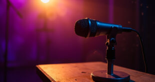 Empty professional podcast studio with vintage microphone on recording table, illuminated in purple and gold lighting
