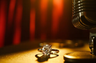Sparkling diamond ring positioned next to classic recording microphone in warm studio lighting
