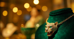 Cartier panther necklace with emerald eye displayed on luxury velvet stand in elegant jewelry boutique display case