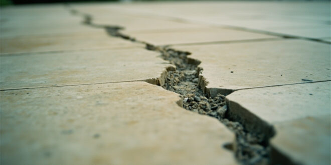 Close-up view of cracked limestone patio stone showing deep gash damage in White House Rose Garden construction
