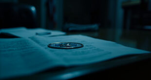 Government memo with official seal on wooden desk surrounded by scattered papers in dimly lit office