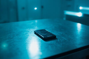 Smartphone displaying call logs as digital evidence in a sterile forensic laboratory under cold blue lighting