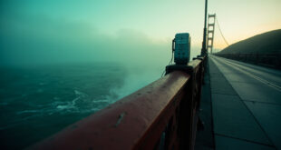 Golden Gate Bridge safety railing with emergency call box overlooking San Francisco Bay waters below.