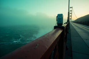 Golden Gate Bridge safety railing with emergency call box overlooking San Francisco Bay waters below.
