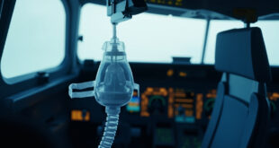 Emergency oxygen mask deployed in commercial aircraft cockpit with instrument panel background