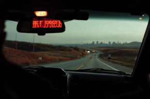 Black taxi cab on empty country road with digital meter showing high fare, distant city buildings on horizon