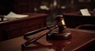 Wooden judge gavel on dark mahogany bench in empty parliamentary chamber