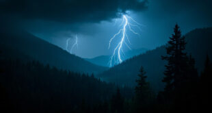Dramatic lightning bolt striking through dark storm clouds over Colorado mountain wilderness forest