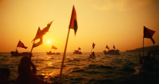 Fleet of vessels with Palestinian flags departing Barcelona port at dusk carrying humanitarian supplies