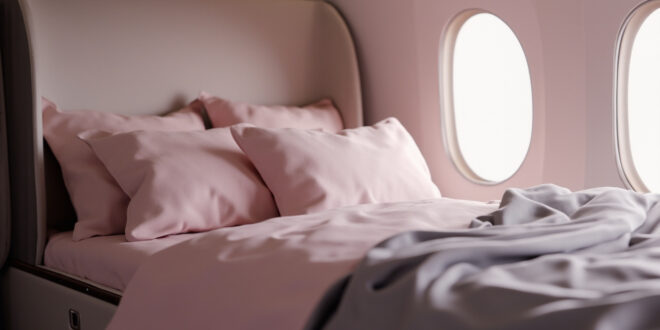 Private jet cabin interior with comfortable bed covered in soft blankets and pillows