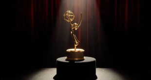 Golden Emmy trophy on dark podium under dramatic stage spotlights