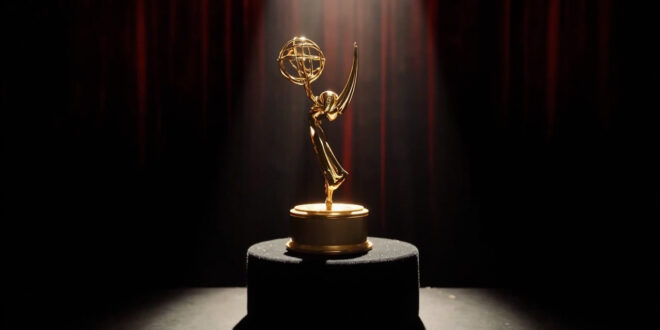 Golden Emmy trophy on dark podium under dramatic stage spotlights