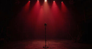 Empty television studio with single microphone stand on darkened stage, abandoned chairs and cameras in shadows