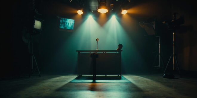 Empty late night television studio with vintage microphone on host desk, cameras and lighting equipment visible in shadows