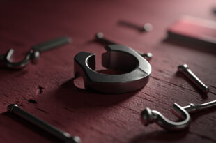 Two broken wedding rings separated on aged wood surface with scattered rose petals and torn papers.