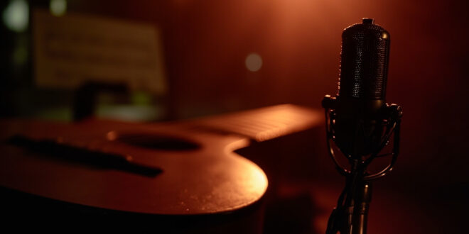 Recording studio setup with acoustic guitar, microphone, and warm lighting creating intimate musical atmosphere