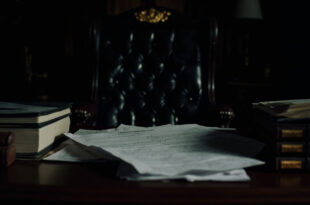 Empty executive office desk with scattered official documents and brass nameplate in formal government setting