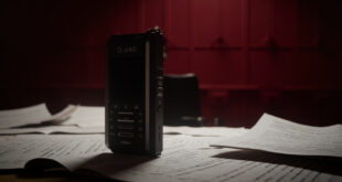 Audio recorder on desk with redacted documents, empty chairs, and official government office setting