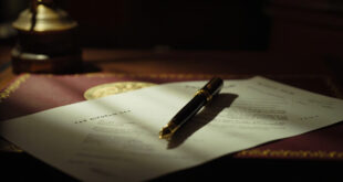 Golden fountain pen on tax reform documents with official government seal on mahogany desk