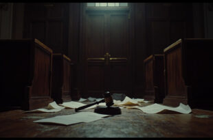 Heavy wooden courthouse doors with brass handles, representing legal proceedings and judicial decisions.