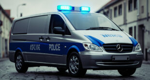 Silver Mercedes van with blue LED light bar on roof being loaded onto tow truck by authorities
