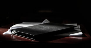 Closed psychiatric evaluation folder with official seals on wooden courtroom bench in secure institutional setting
