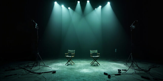 Two separated director chairs on dark television studio set with broken lighting equipment and tangled cables