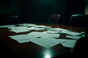 Empty boardroom table with scattered official documents and vacant leather chairs in dramatic lighting