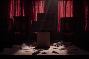Empty voting booth with scattered ballot papers and official seals in dark municipal office with closed stations