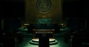 Empty UN General Assembly podium with green marble walls and diplomatic seating in dramatic lighting