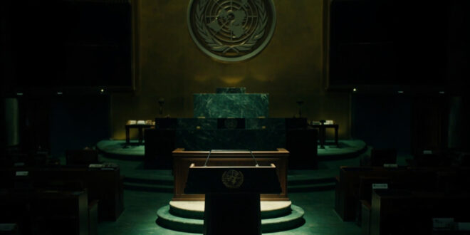 Empty UN General Assembly podium with green marble walls and diplomatic seating in dramatic lighting