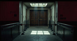 Empty Capitol corridor with metal security barriers and closed wooden doors under dim institutional lighting