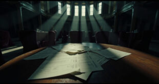 Empty wedding venue with draped tables and scattered contract documents in moody lighting