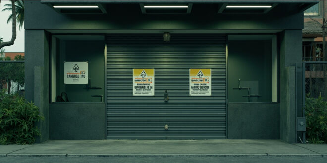 Closed storefront with metal security gates in tropical commercial area, showing an empty cannabis dispensary