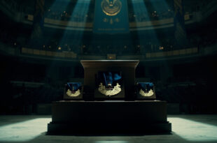 Empty military ceremony hall with draped flags and vacant podium under dramatic lighting
