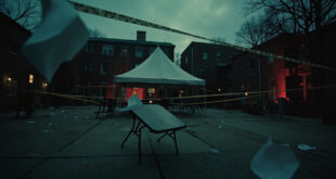Empty white tent and overturned table on university campus with scattered papers and police tape