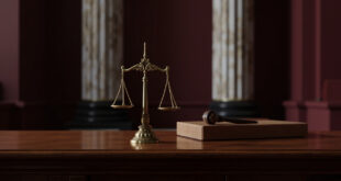 Bronze scales of justice on wooden desk in formal courthouse setting with marble columns