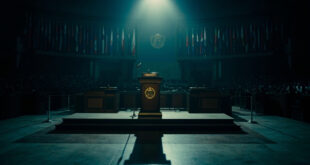 Empty UN General Assembly podium with microphone and scattered diplomatic flags in darkened chamber