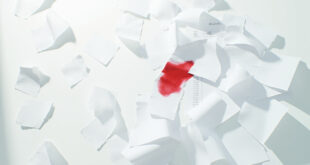 Stacks of budget documents with red markings scattered across empty government office desk with calculators