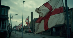 Red and white St George flags flying on lampposts outside cream brick council building with glass facade