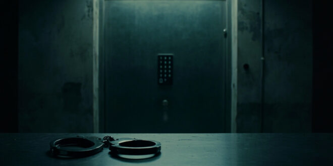 Empty handcuffs on steel interrogation table in stark government facility