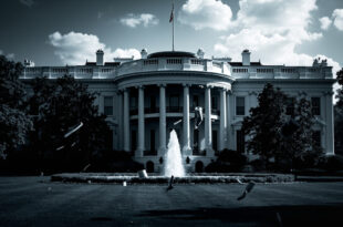 Open second-story White House window with dark objects scattered on lawn below against bulletproof glass