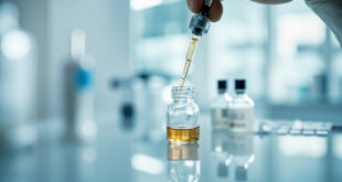 Medical syringe drawing clear liquid from glass vial in sterile clinical setting with cool blue lighting