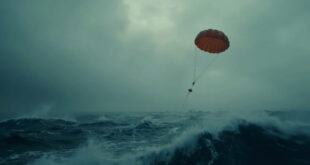Orange sonar buoy with parachute falling toward dark Atlantic ocean surface from aircraft
