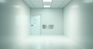 Empty hospital corridor with fluorescent lighting and closed patient room door