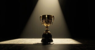 Golden football trophy on black marble pedestal in dramatic spotlight with geometric shadows