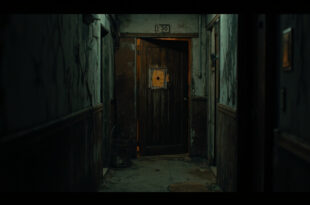 Damaged apartment door with bullet hole in shadowy hallway of residential complex