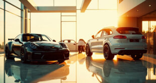 Black Porsche 911 sports car parked next to silver Porsche Cayenne SUV in modern dealership showroom