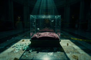 Shattered glass display case with empty velvet cushion in ornate museum gallery under dramatic lighting