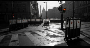 Metal police barriers and orange traffic cones scattered on empty Berlin street after demonstration